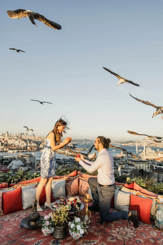 Man proposing on an Istanbul rooftop while the woman wears a blue floral dress