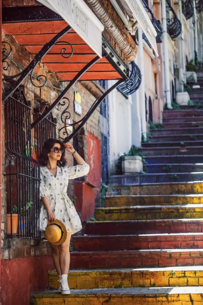 Woman wearing a light summer outfit for a photoshoot in Istanbul on the colorful Balat stairs