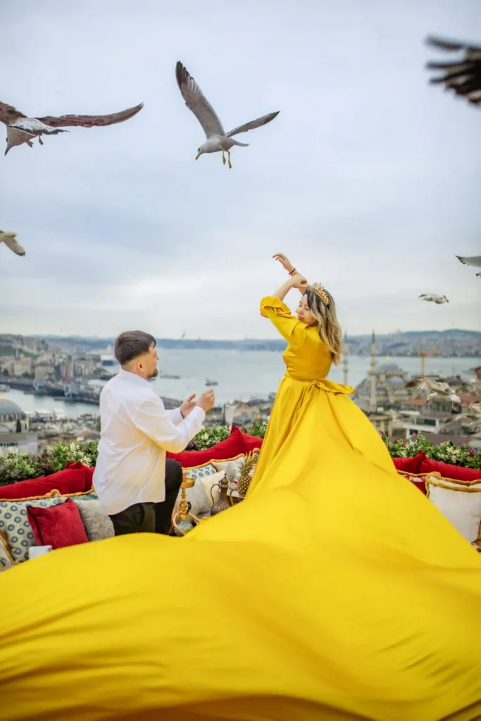 Romantic flying dress proposal photoshoot on an Istanbul rooftop overlooking the city skyline.